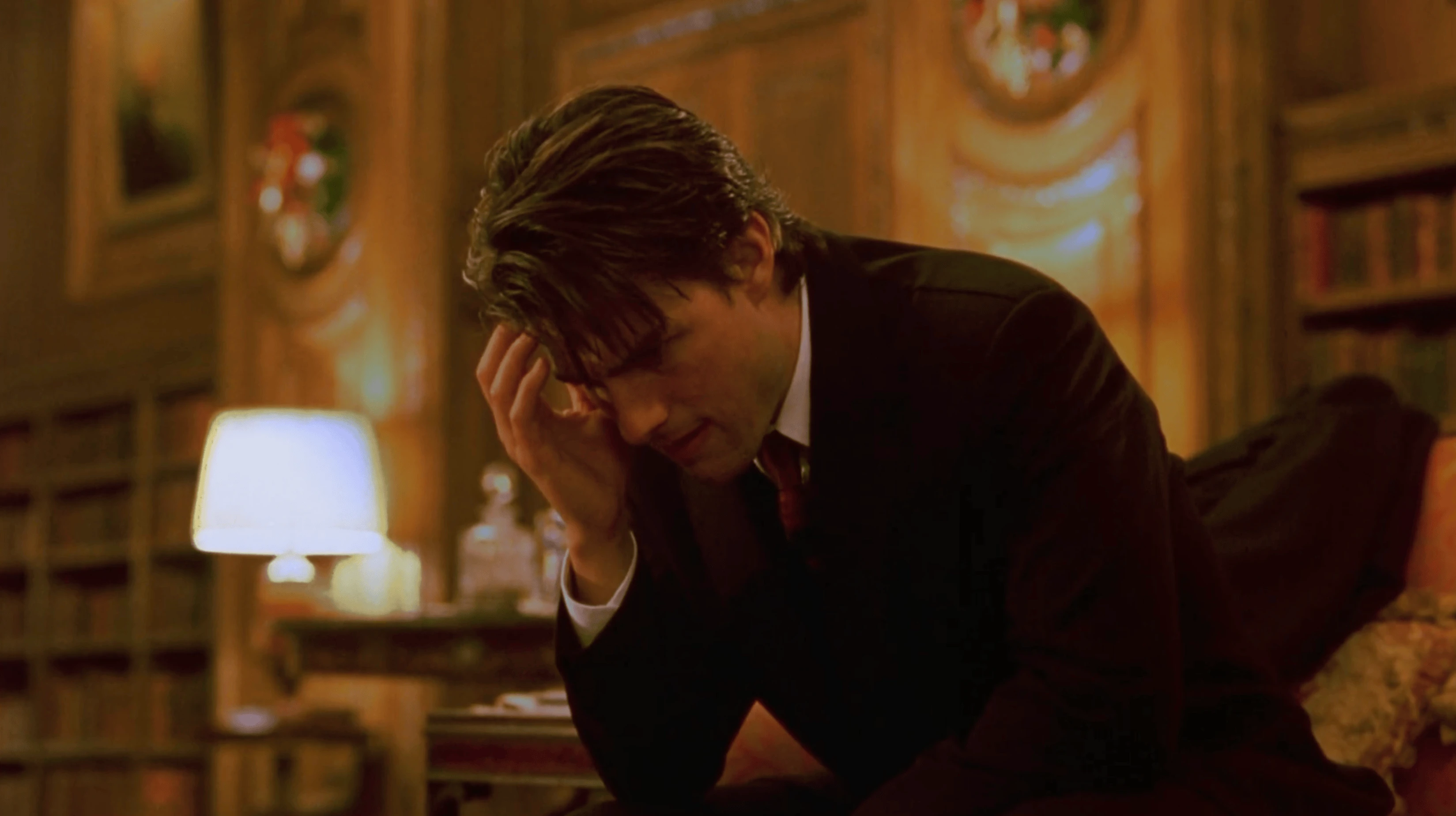 Bill effondré, tête dans les mains, seul dans une bibliothèque